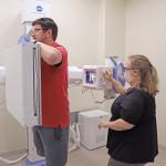 Nurse practitioner performs a chest x-ray on a patient