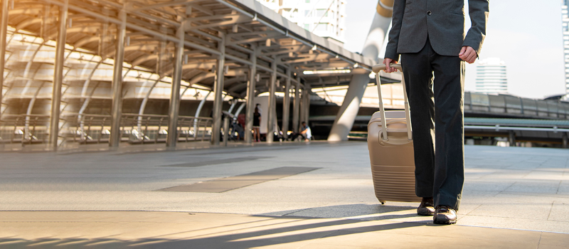 A traveler with a rolling case - courtesy Getty Images